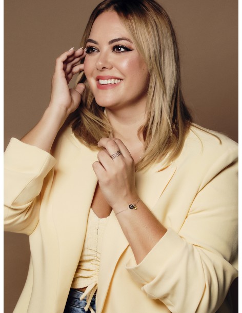 Foto de la modelo Ceci Wallace con una pulsera con letras y 